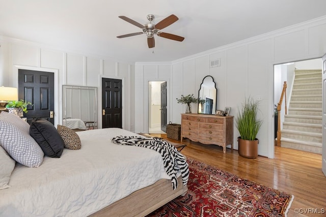 2951 W Maple Grove Ln, Powhatan, VA 23139 - bedroom featuring wood finished floors, ornamental molding, a decorative wall, and a ceiling fan
