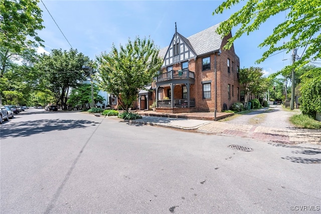 view of front of house featuring brick siding and a balcony