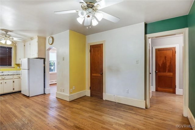 102 Norman Dr, Henrico, VA 23227 - interior space with freestanding refrigerator, light wood-style floors, ceiling fan, white cabinetry, and arched walkways
