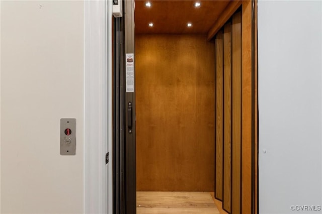 room details with recessed lighting, elevator, and wood finished floors