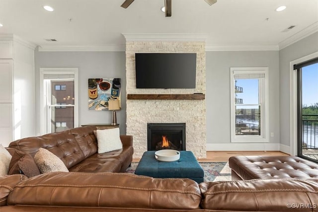 living room featuring a ceiling fan, recessed lighting, a stone fireplace, and wood finished floors