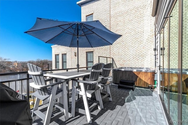 exterior space featuring a patio, outdoor dining area, and a hot tub