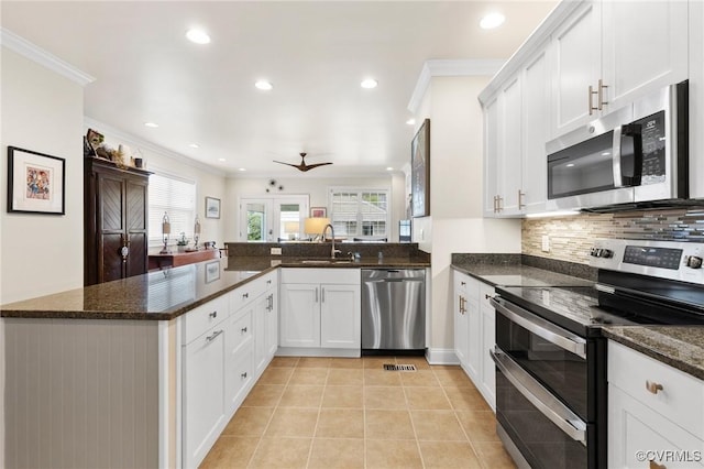 4708 Hanover Ave, Richmond, VA 23226 - kitchen featuring crown molding, light tile patterned flooring, appliances with stainless steel finishes, a sink, and a peninsula