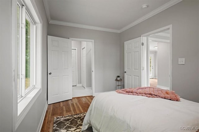 bedroom featuring dark wood-style flooring, baseboards, and ornamental molding