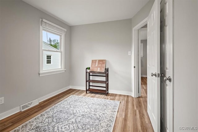 interior space featuring baseboards, visible vents, and light wood-type flooring
