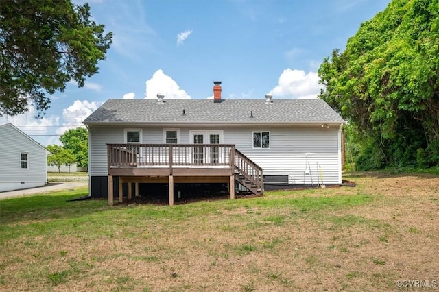 rear view of property featuring a chimney, a yard, and a deck