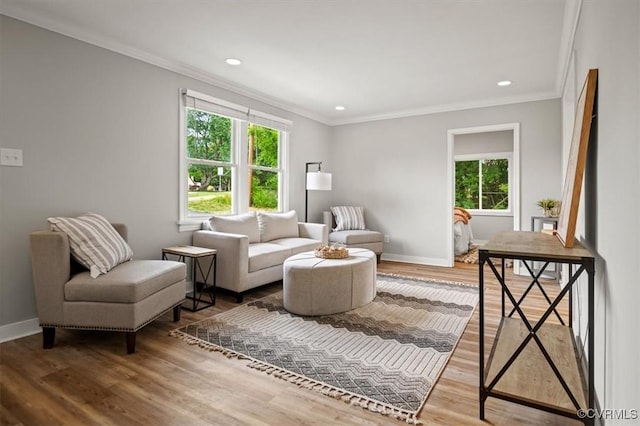 sitting room featuring crown molding, baseboards, and wood finished floors