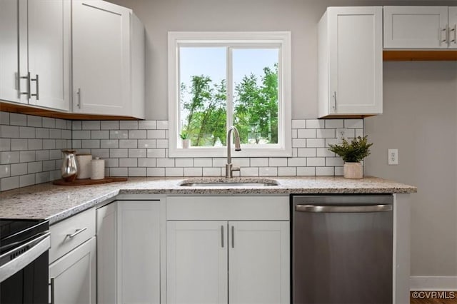 kitchen featuring a sink, white cabinetry, appliances with stainless steel finishes, and decorative backsplash