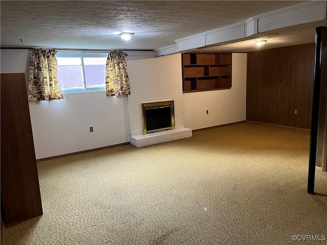 basement with carpet floors, a textured ceiling, a brick fireplace, and wooden walls