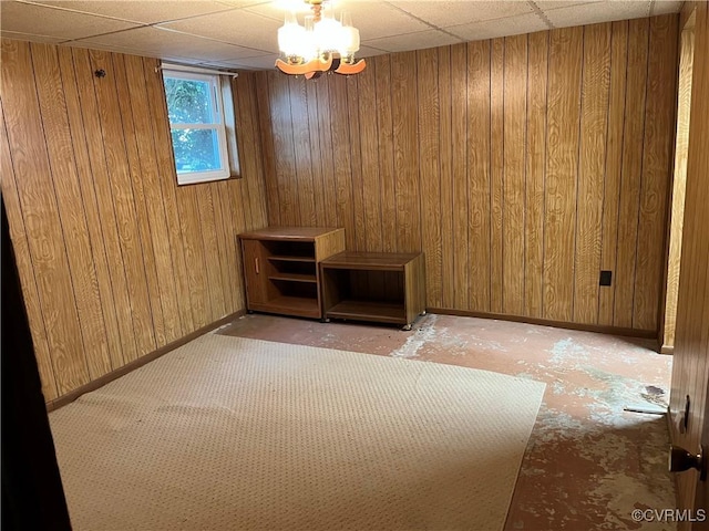 unfurnished room with wooden walls and baseboards