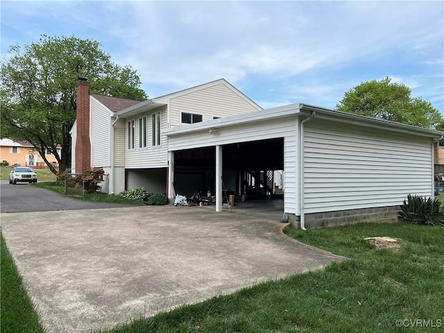 view of side of property featuring driveway and a chimney