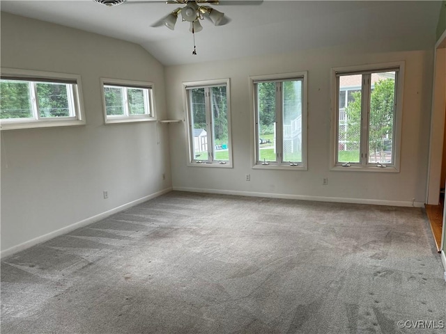unfurnished room with a ceiling fan, visible vents, baseboards, lofted ceiling, and carpet