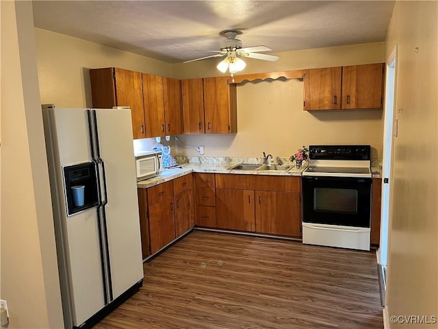 kitchen with a sink, white refrigerator with ice dispenser, stainless steel microwave, electric stove, and dark wood finished floors