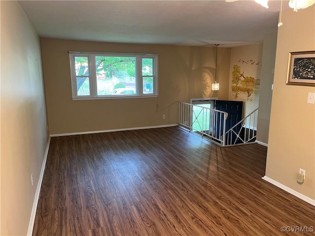 unfurnished living room with baseboards and wood finished floors