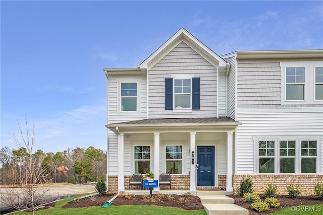 view of front of house with a porch and brick siding