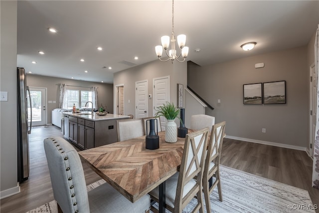 dining room featuring an inviting chandelier, recessed lighting, baseboards, and wood finished floors