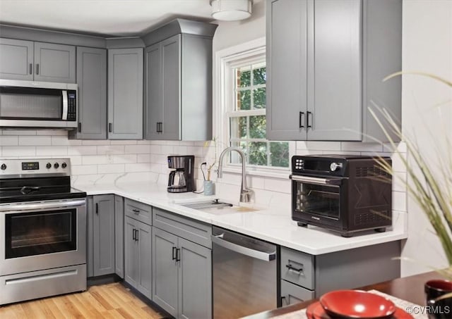 112 Webster Rd, Sandston, VA 23150 - kitchen featuring stainless steel appliances, gray cabinetry, a sink, and tasteful backsplash