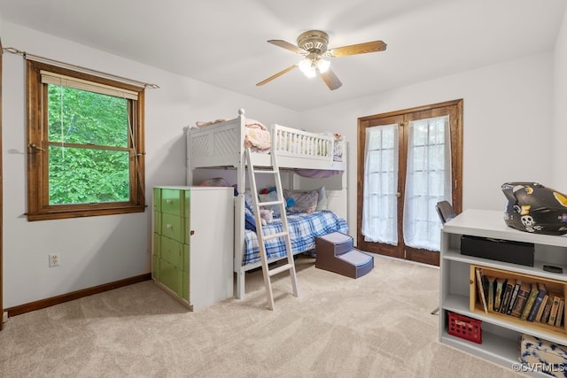 bedroom with carpet floors, a ceiling fan, baseboards, and multiple windows