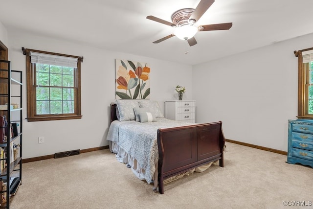 bedroom featuring baseboards, light colored carpet, and multiple windows
