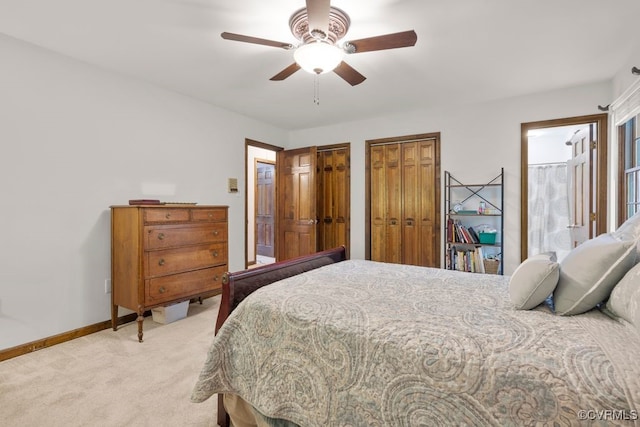 bedroom featuring baseboards, multiple closets, ceiling fan, and light carpet