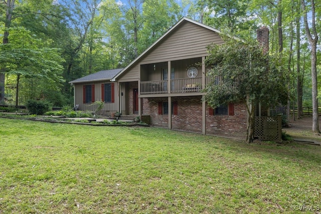 back of property with a lawn, brick siding, and a chimney