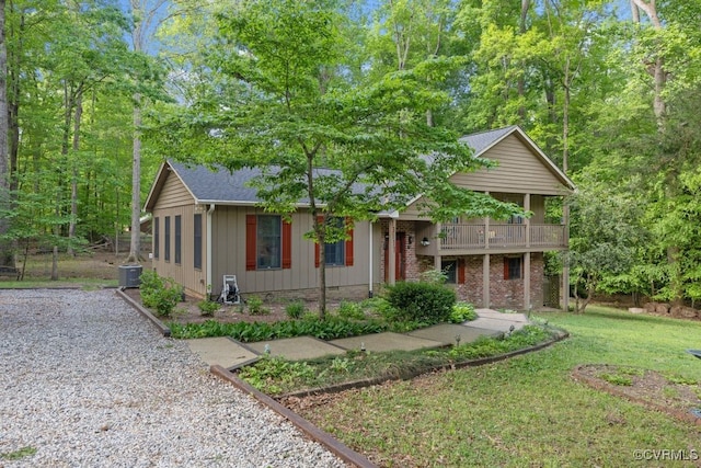 view of front of home featuring board and batten siding, central AC, and a front lawn