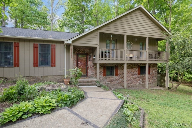 view of front of property featuring brick siding, a front lawn, board and batten siding, and a balcony