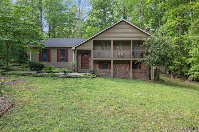 split level home with brick siding, a front lawn, and a chimney