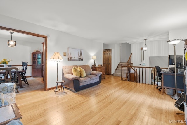 living area with light wood-style flooring and stairway