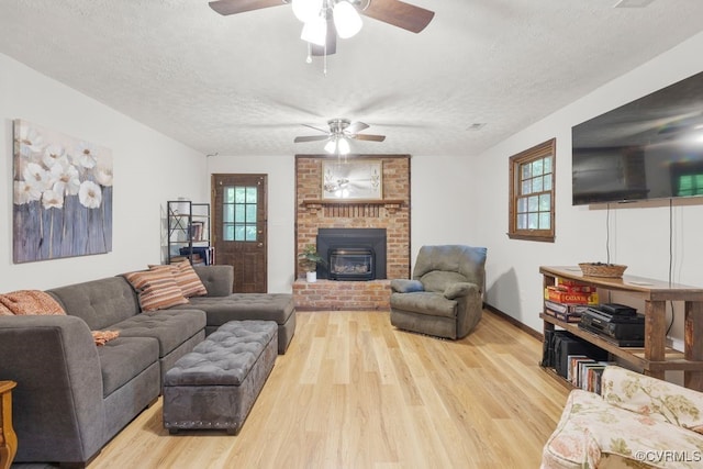 living room with ceiling fan, a textured ceiling, and a wealth of natural light