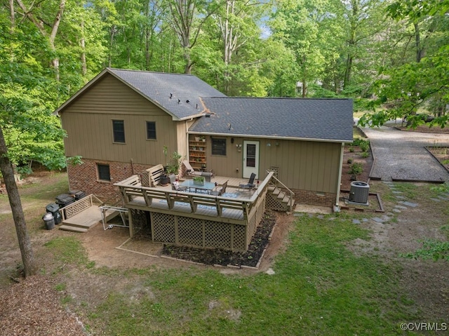 back of house with cooling unit, a wooden deck, and roof with shingles