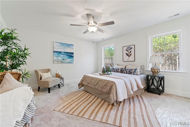 bedroom featuring baseboards, visible vents, light carpet, and ceiling fan