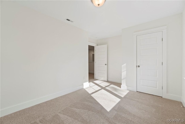 unfurnished bedroom featuring baseboards, visible vents, light carpet, and a closet