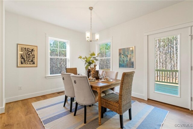 dining room featuring baseboards, a chandelier, and light wood-style flooring