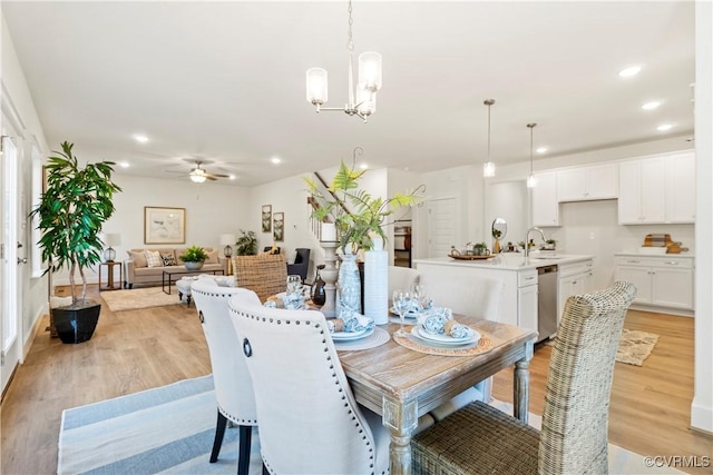 dining area featuring recessed lighting, light wood-style flooring, and ceiling fan with notable chandelier
