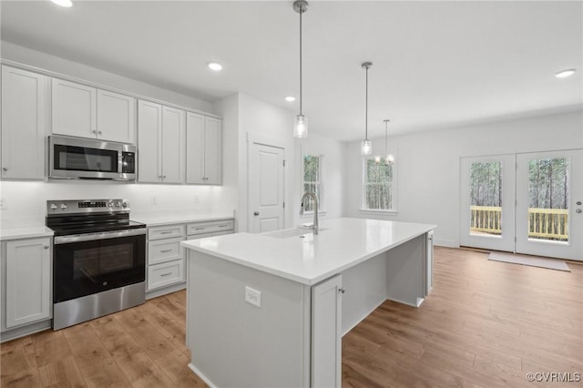 kitchen with recessed lighting, a sink, light wood-style flooring, and appliances with stainless steel finishes