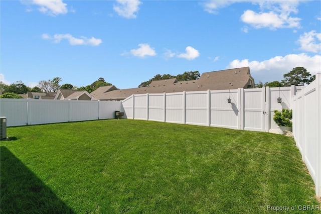 view of yard with central air condition unit and a fenced backyard