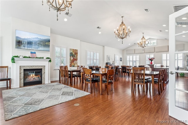 dining space featuring visible vents, wood finished floors, and a notable chandelier