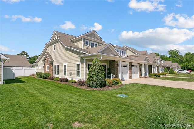 view of front of house with a garage, a front lawn, fence, stone siding, and concrete driveway