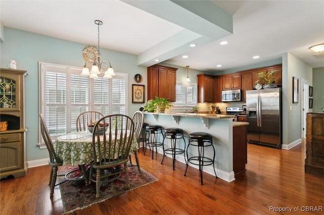 dining space featuring recessed lighting, baseboards, a chandelier, and dark wood-style floors