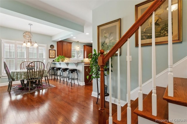 dining room featuring dark wood finished floors, recessed lighting, stairs, and a notable chandelier
