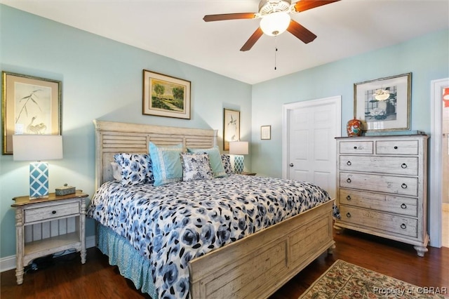 bedroom with a ceiling fan, baseboards, and dark wood-type flooring