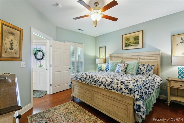 bedroom featuring dark wood-style flooring, baseboards, visible vents, and a ceiling fan