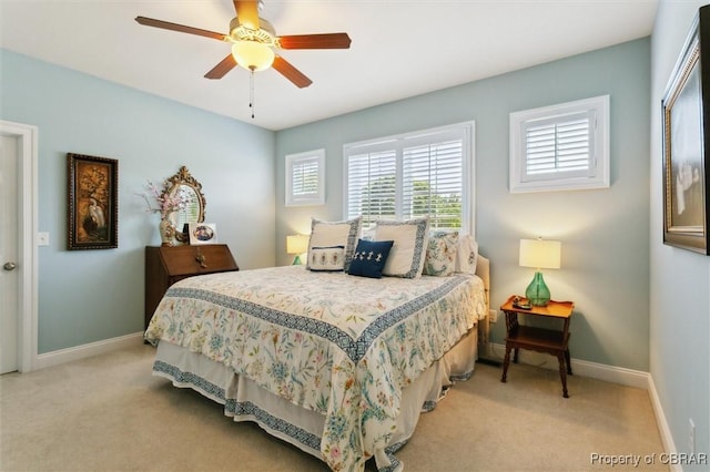bedroom featuring baseboards, light carpet, and ceiling fan