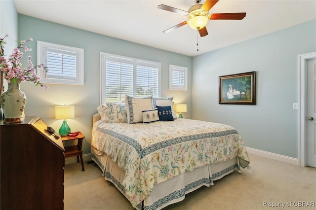 bedroom featuring a ceiling fan, baseboards, and light colored carpet