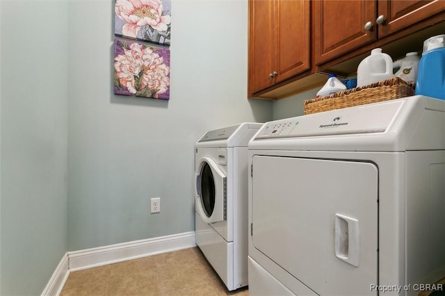 laundry area with cabinet space, separate washer and dryer, and baseboards