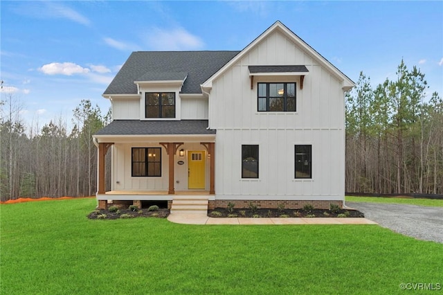 modern farmhouse with a shingled roof, covered porch, board and batten siding, and a front yard