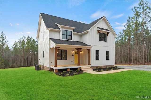 modern farmhouse featuring a front lawn, board and batten siding, central AC, and covered porch