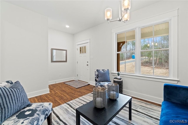 living area featuring an inviting chandelier, baseboards, recessed lighting, and wood finished floors