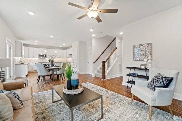 living area featuring stairs, recessed lighting, ceiling fan, and wood finished floors